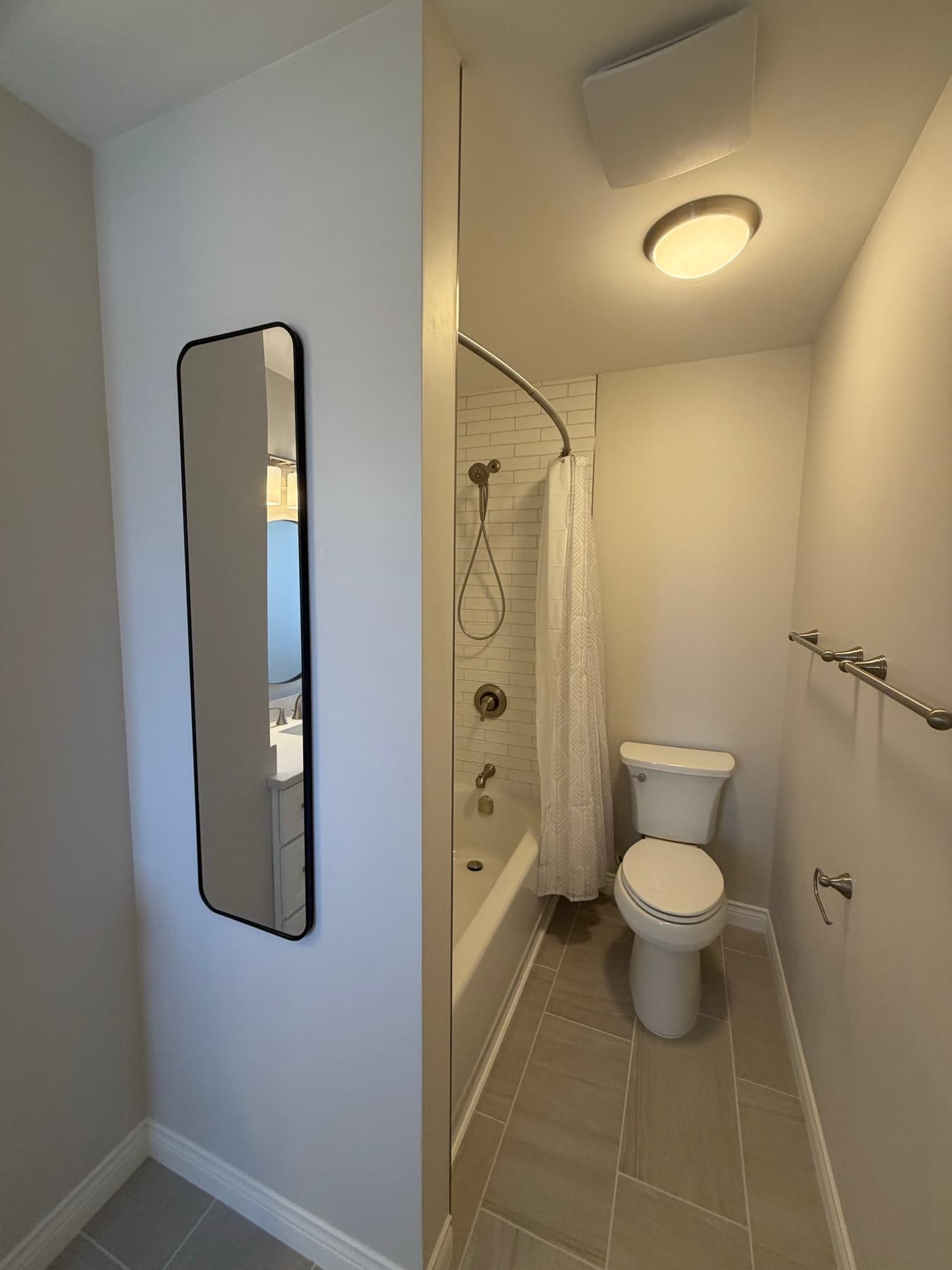 Tub-and-shower combo with a full-height white subway tile surround, brushed nickel fixtures and a curved shower rod